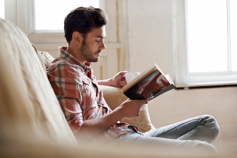 man reading a book with coffee